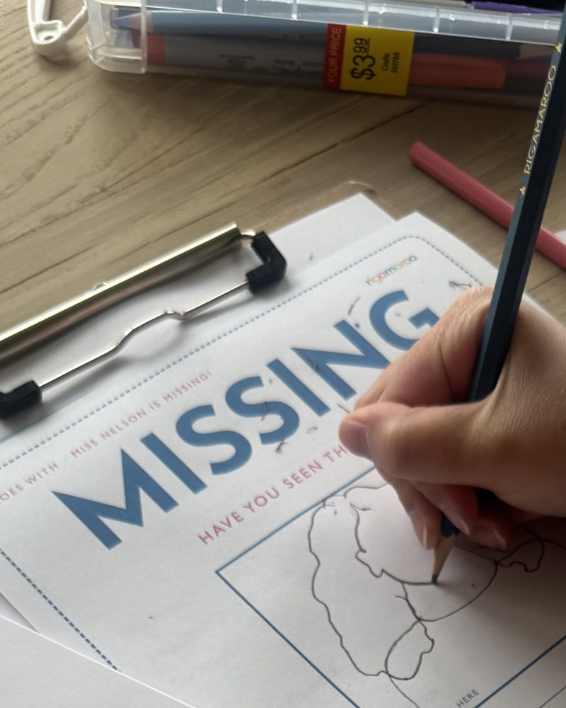 A child drawing Miss Nelson on our MISSING poster with a colored pencil